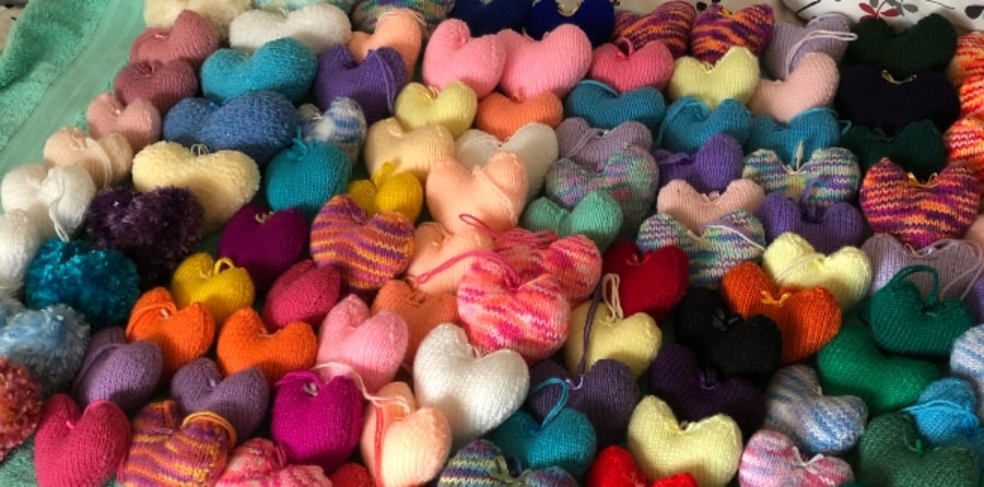 Rows of knitted hearts in various colours.