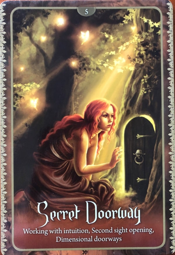 Faery oracle card with lady peering into a door set into a tree trunk, text says, "Secret doorway. Working with intuition, second sight opening, dimensional doorways."